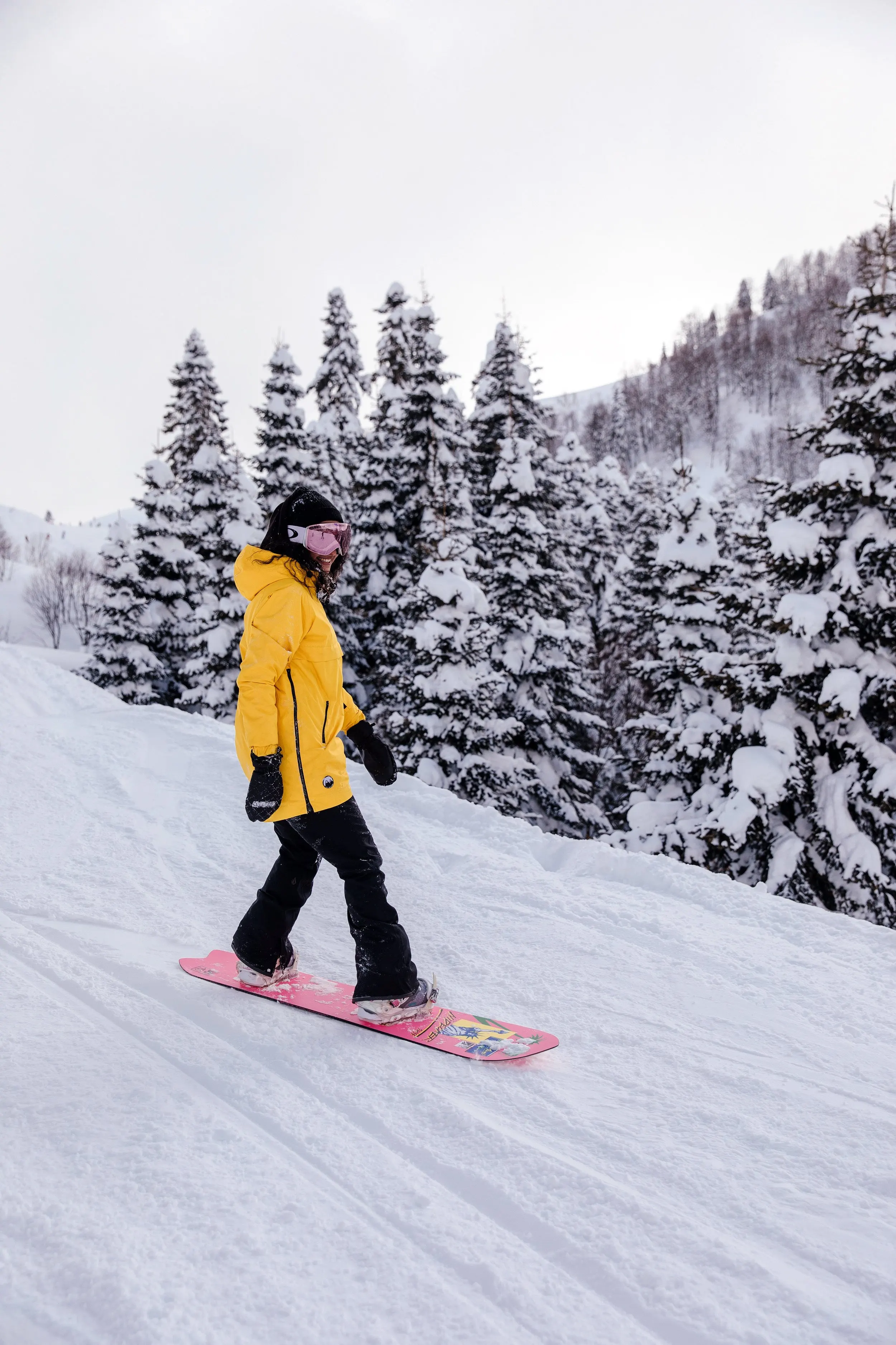 Snowboardzista na stoku wśród ośnieżonych świerków